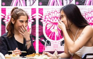 Two young women enjoying a meal at Spice Alley